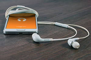 Werbe-Kopfhörer bedrucken Sie bei laprinta In-Ear-Kopfhörer am Handy angeschlossen