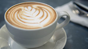 Werbe-Kaffeetasse bedrucken Sie bei laprinta Kaffeetasse mit Unterteller und Milchschaum Baum verziert