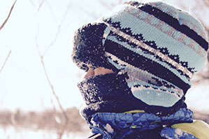 Winter Werbeartikel bedrucken Sie bei laprinta Eine Frau mit Dicker Mütze und dickem Schal eingepackt im Winter