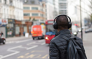 Werbe-Kopfhörer bedrucken Sie bei laprinta On-Ear-Kopfhörer, Mann mit Rucksack auf Straße